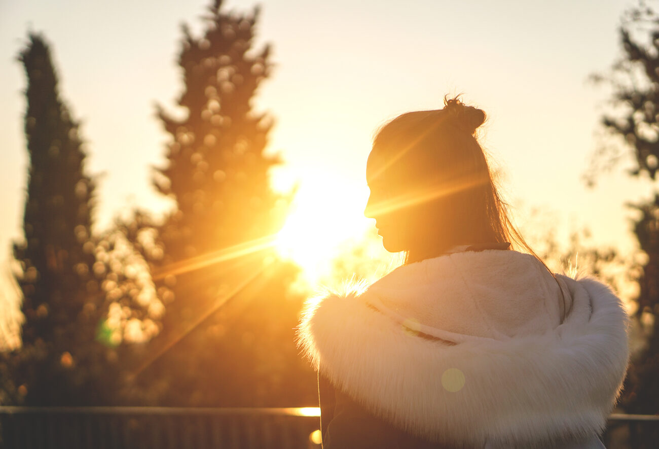 Silhouette of a women in front of the sun