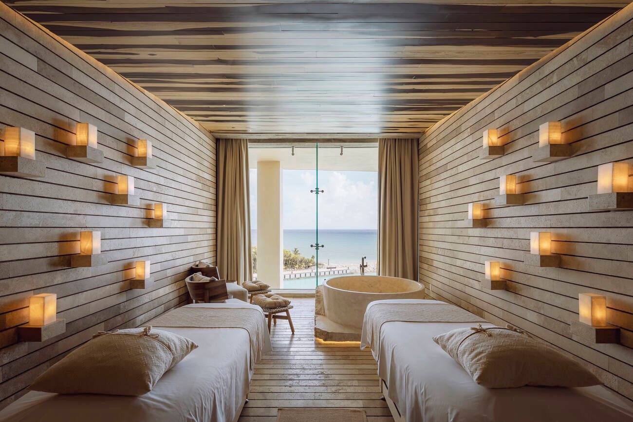 Room with two beds and bathtub overlooking the ocean