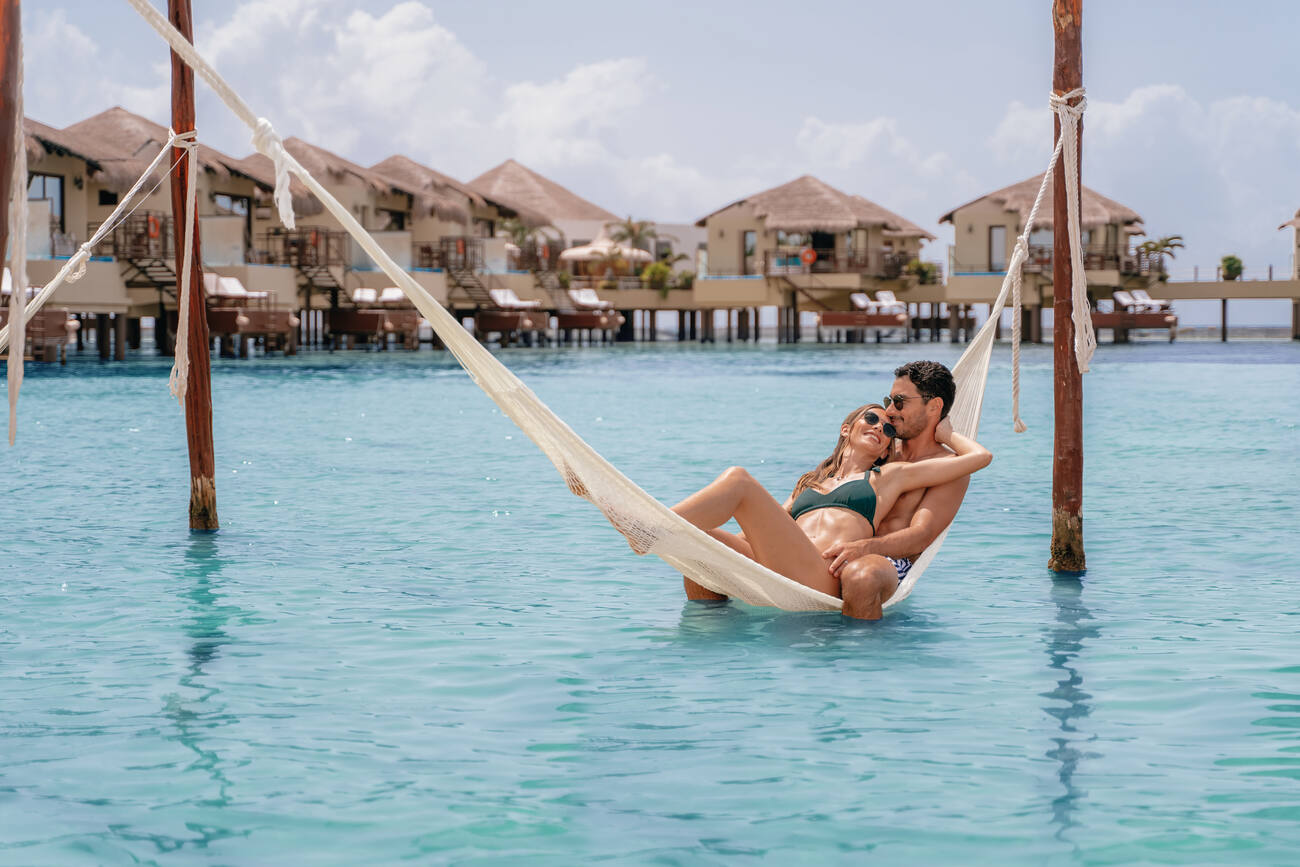 Couple laying in a hammock over the water