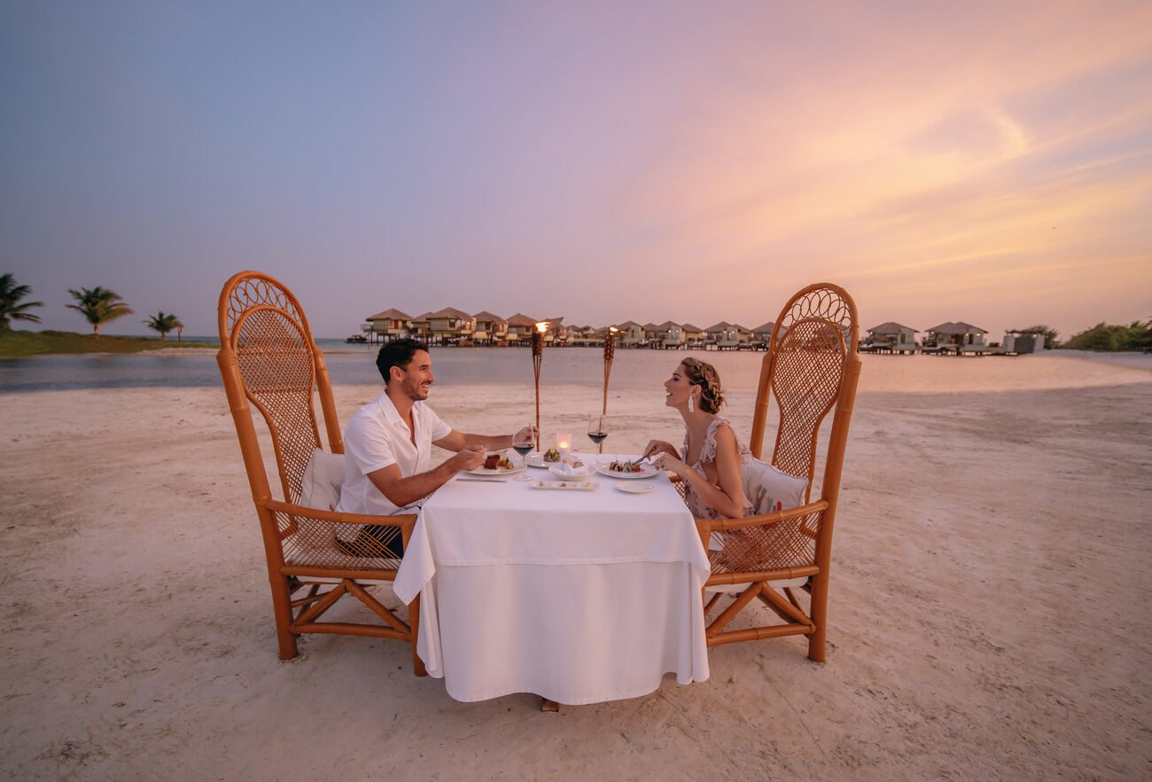 Couple having a candlelit dinner on the beach