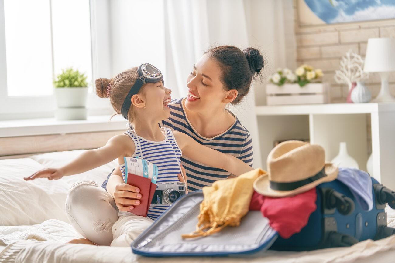 Mother and daughter sitting with their luggage