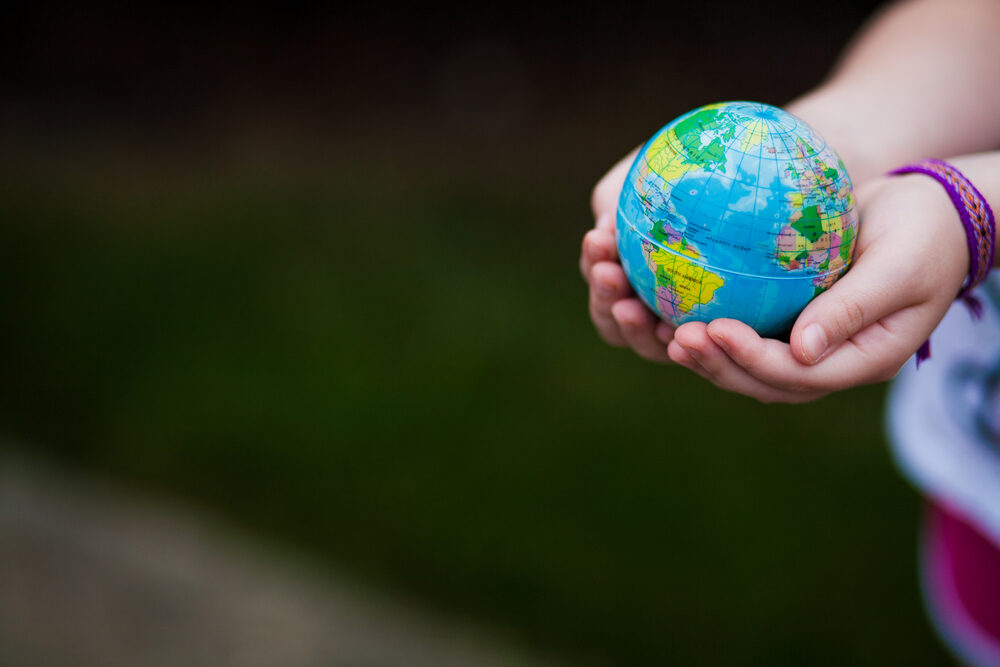Young girl's hands holding a globe.