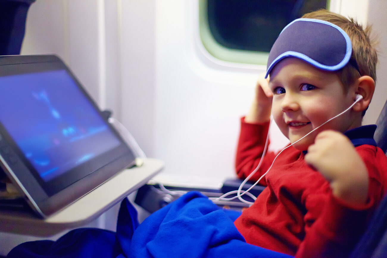 Boy on a plane watching a movie