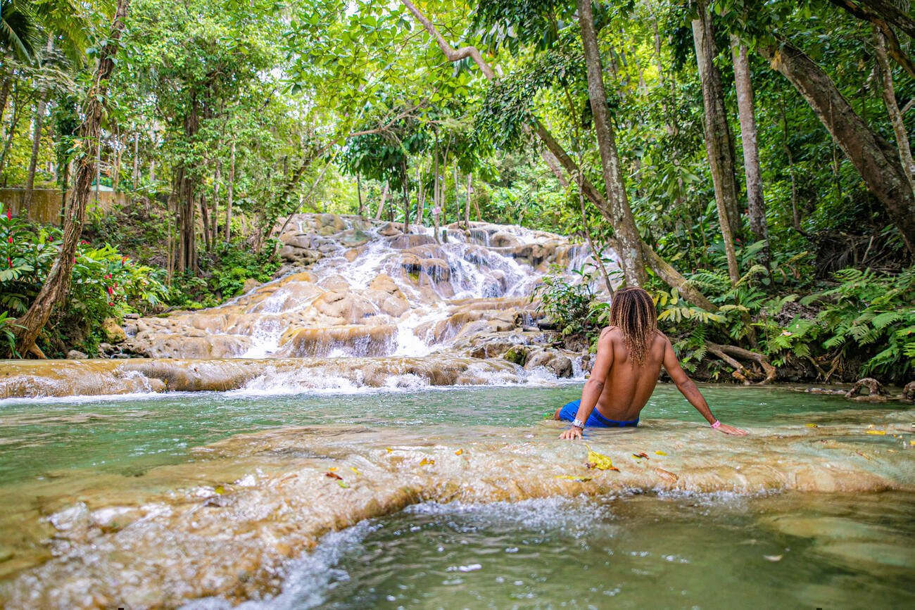 Man sitting on rocks in running water