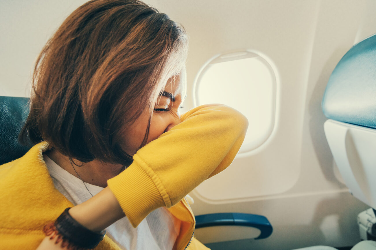 Woman sneezing into her arm