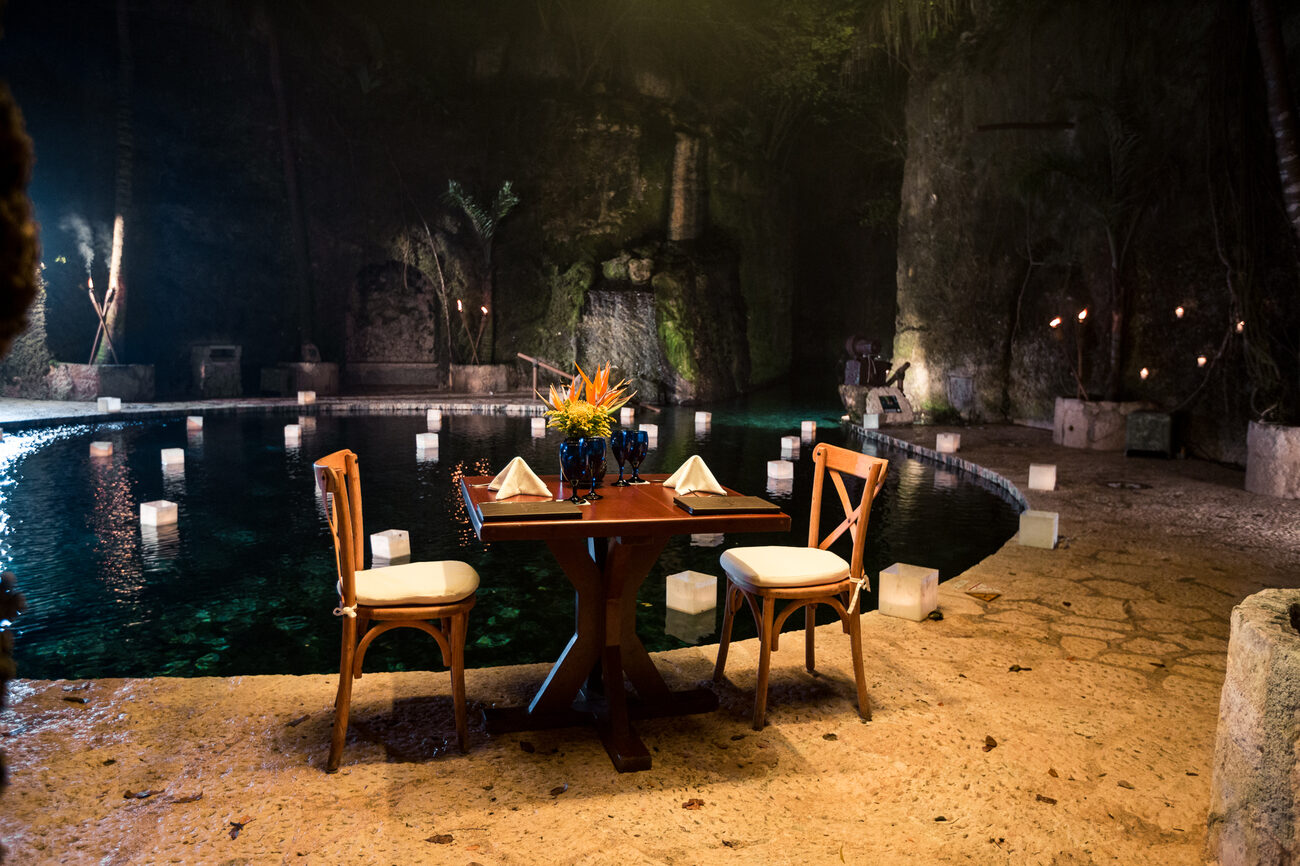 Table for two set over water with floating lanterns 