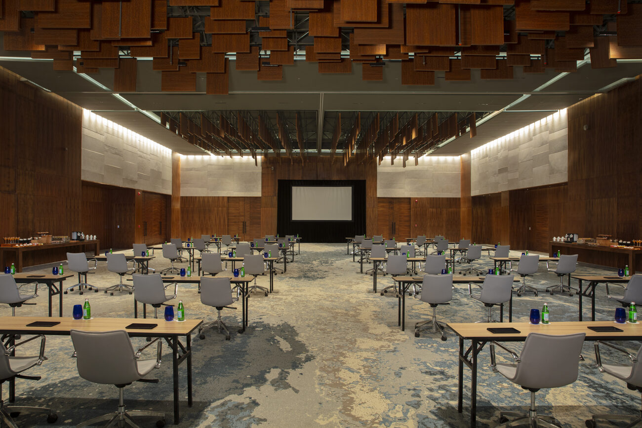 Tables and chairs set up in front of screen in a meeting room