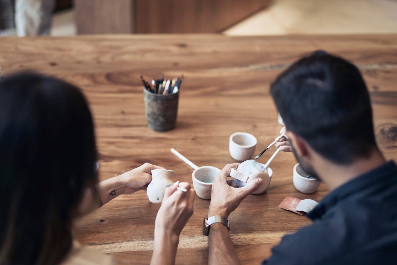 Two people painting ceramics