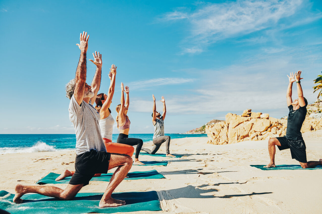 Group doing yoga on the beach