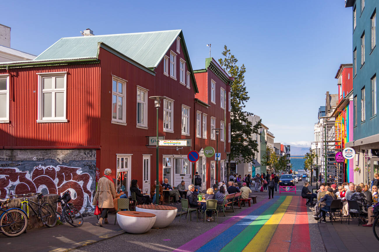 People eating at tables with a pride flag drawn on the walkway