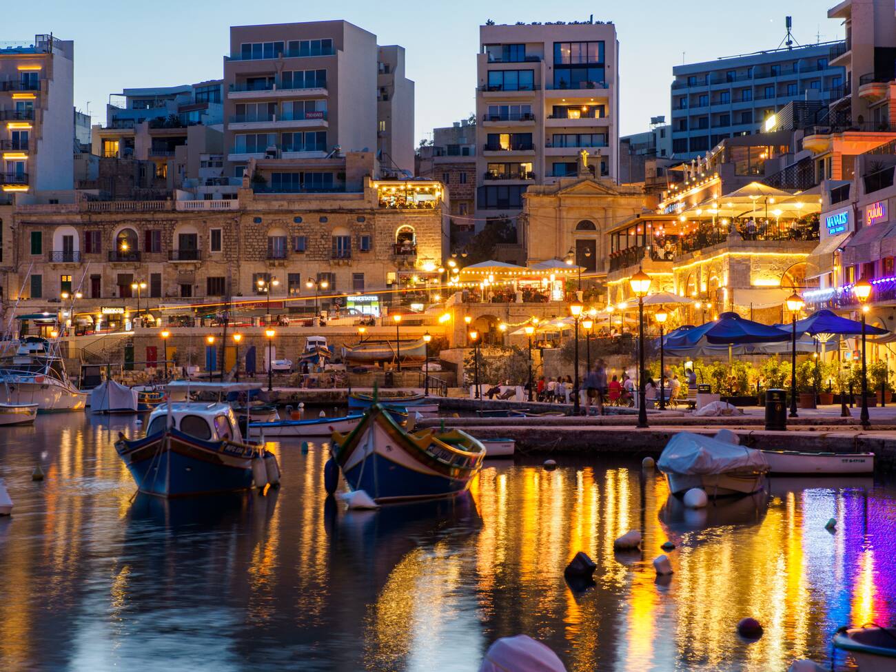 Boats on the water near the town buildings and dock