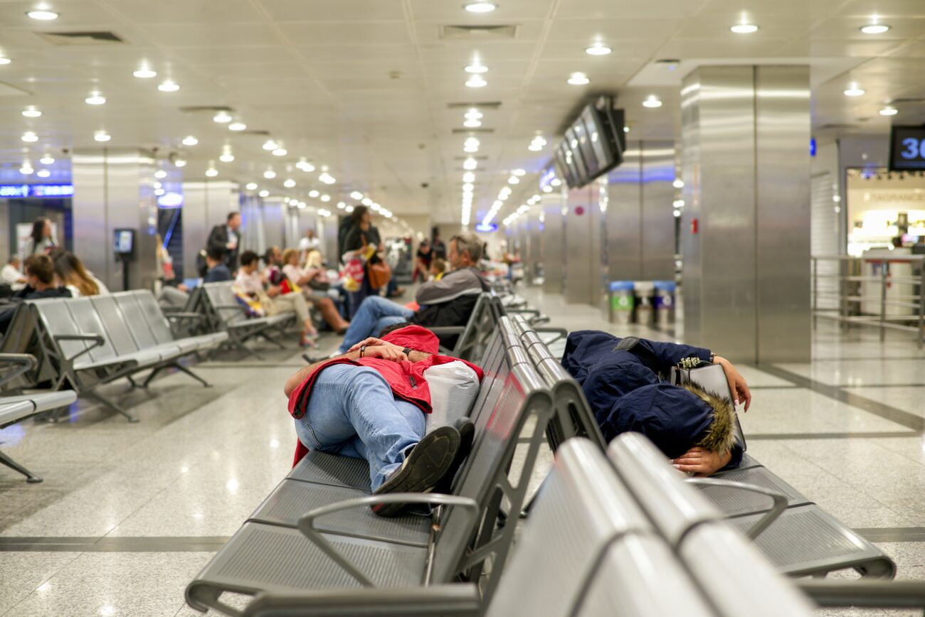 People sleeping on benches at the airport 