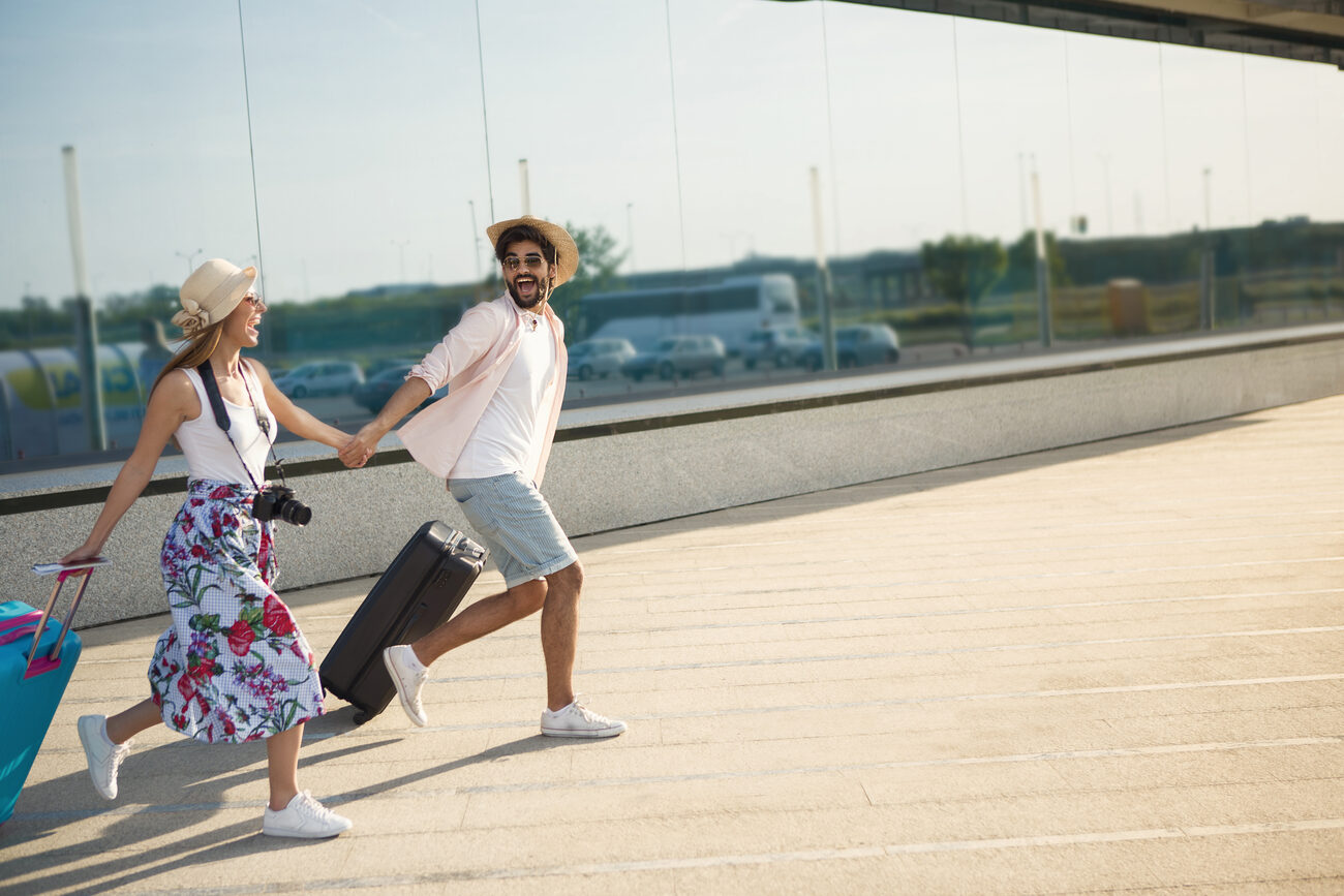 Couple holding hands with their luggage