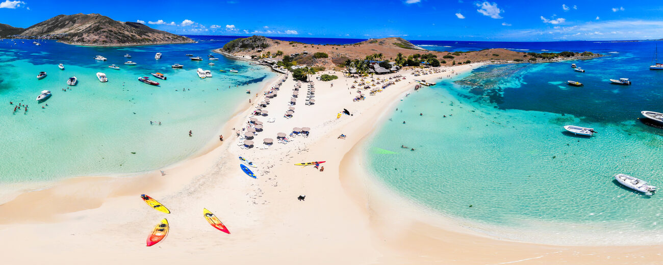 Body of water with boats and paddle boards, islands in the back