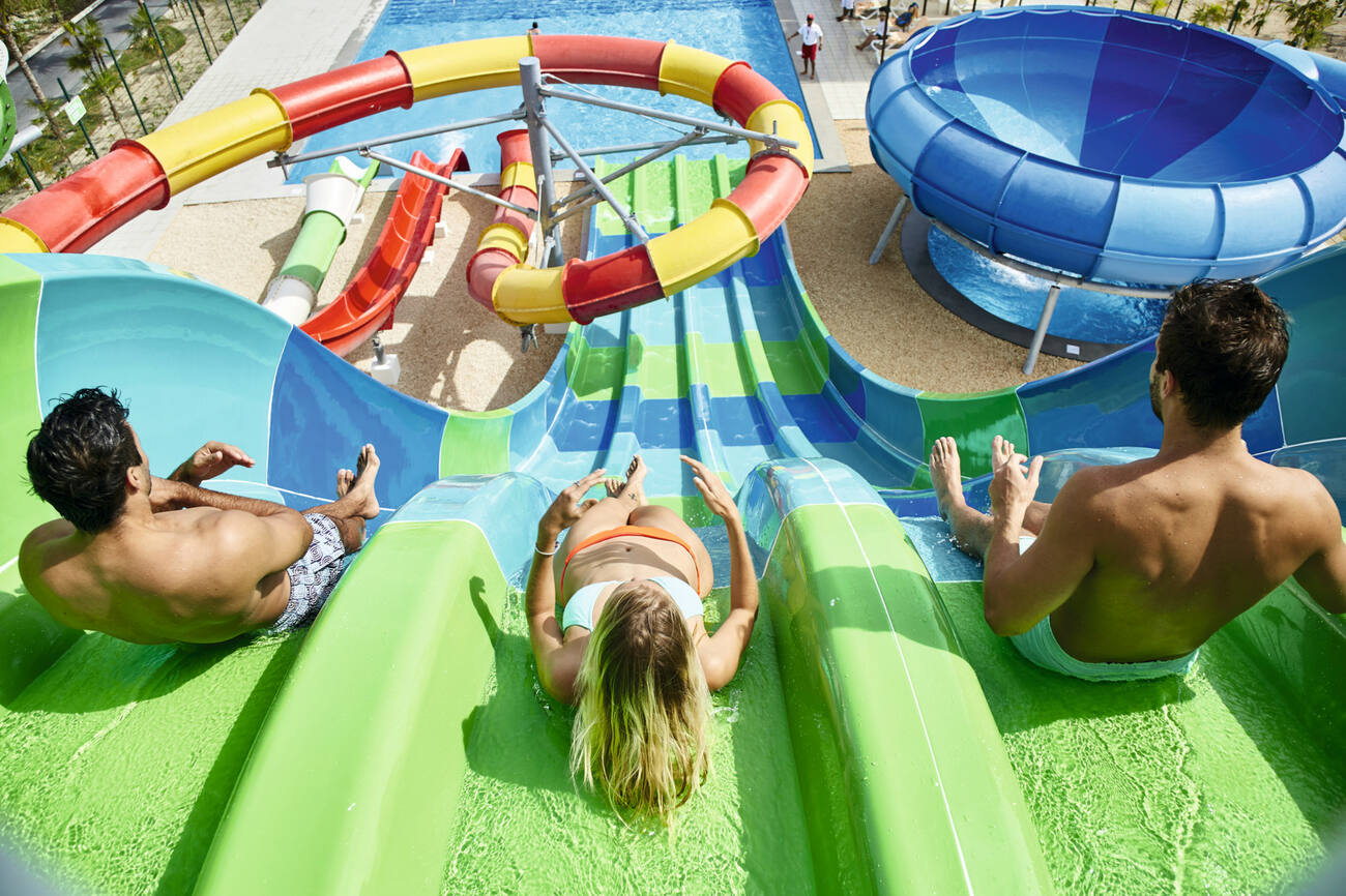 Couple going down a waterslide into a pool