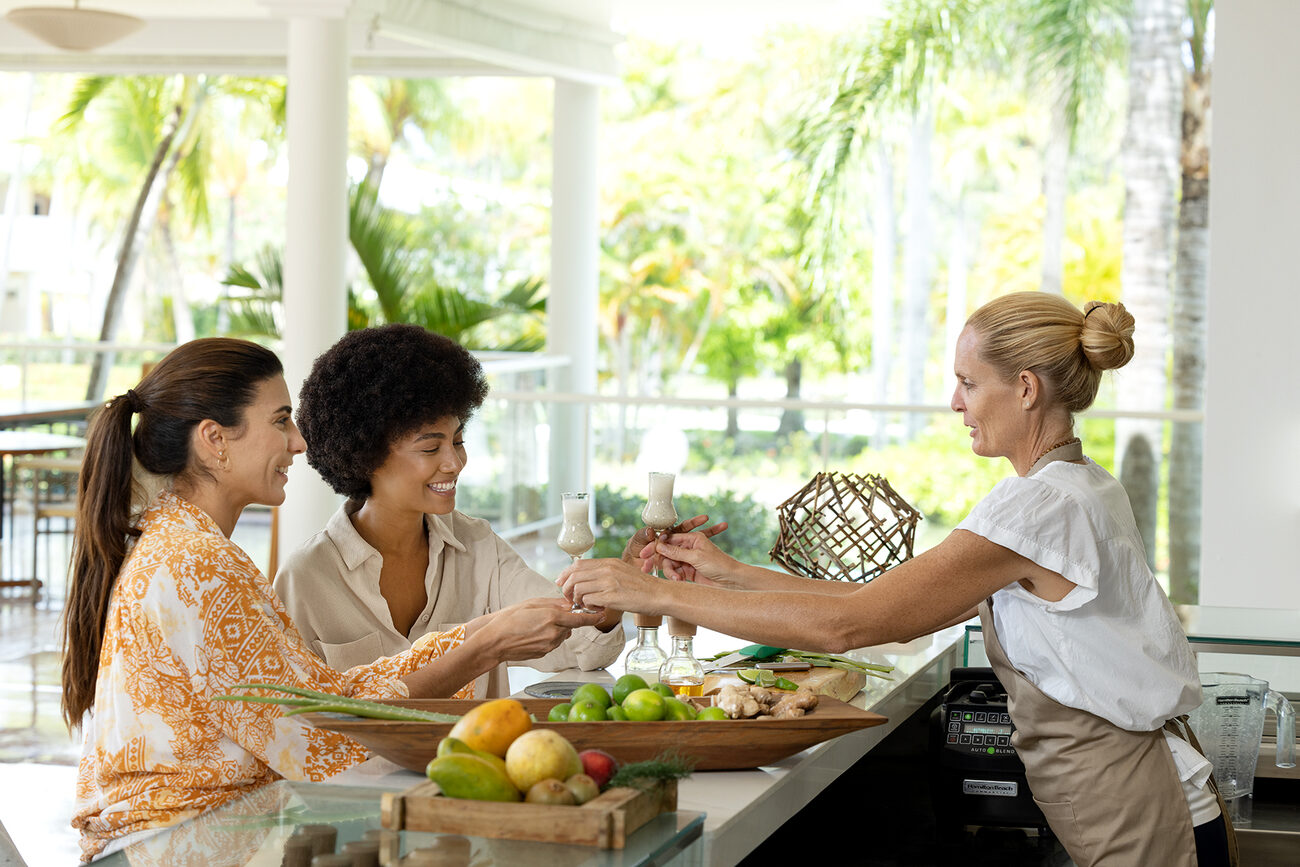 Two women receiving drinks for a bar