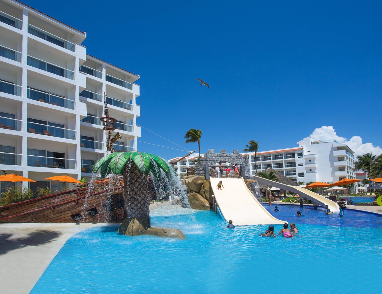 Kids playing in a pool with a slide